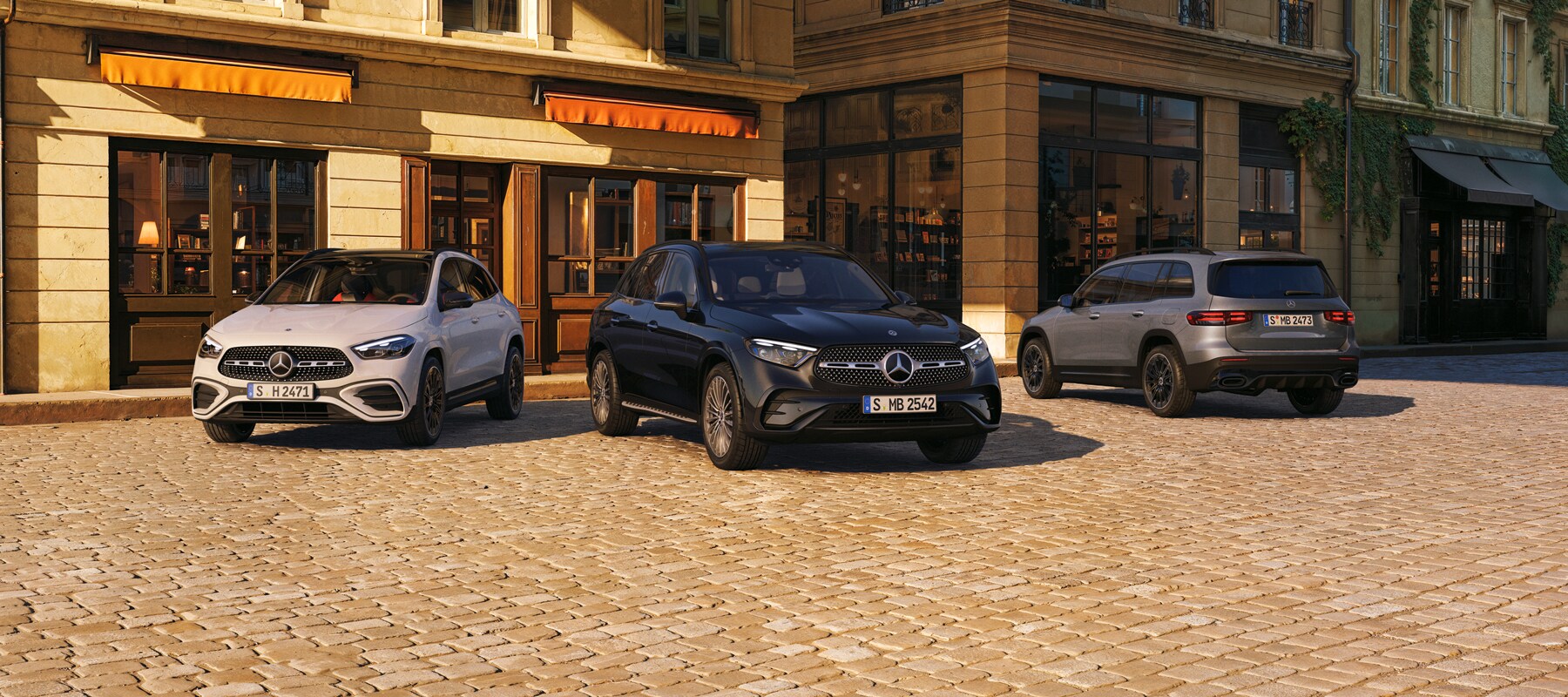 Três modelos Mercedes-Benz em um exterior elegante.