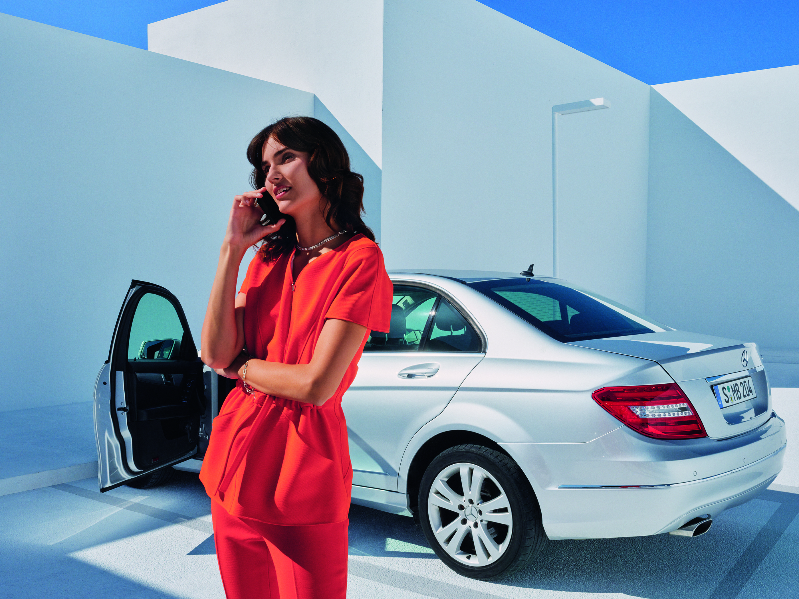 Mercedes Service Uma mulher falando ao telefone em frente a um Mercedes-Benz.