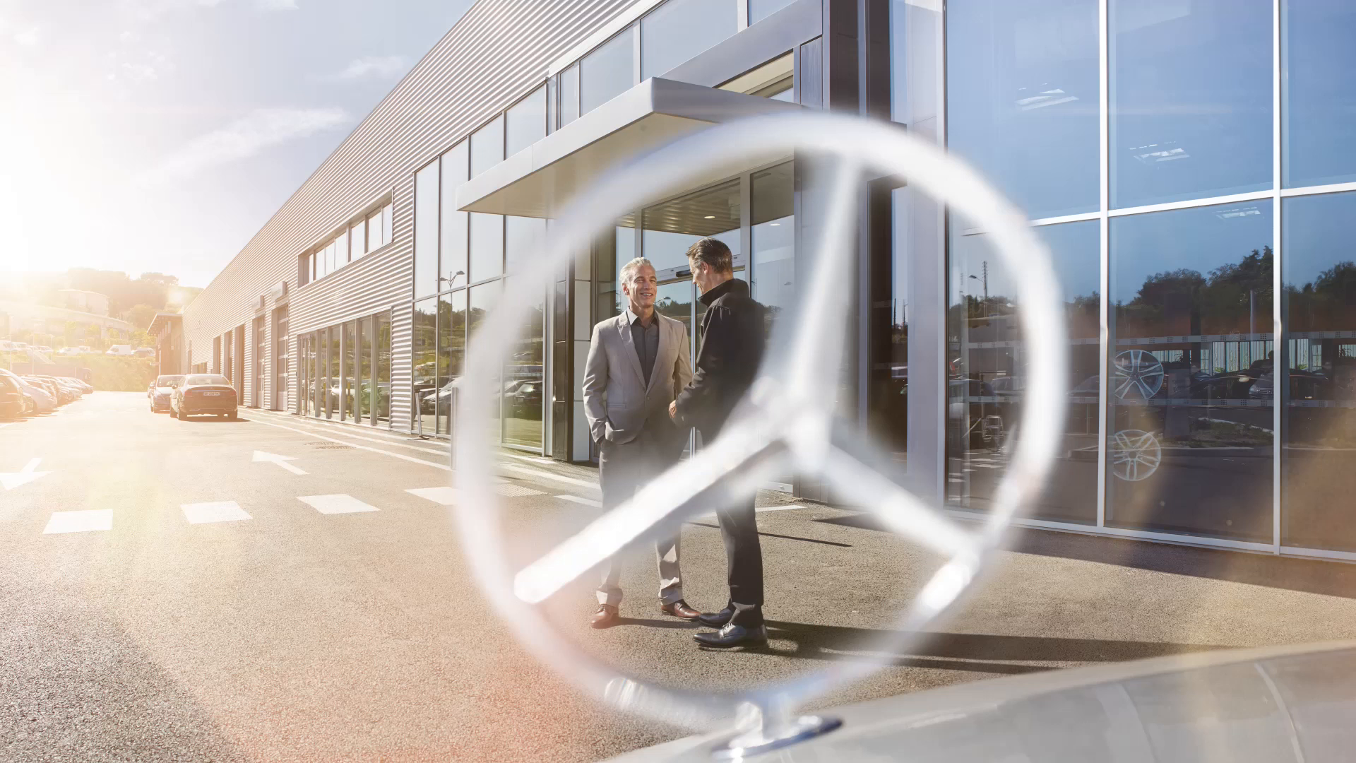 Mercedes Service Duas pessoas conversando em frente a estrela de um Mercedes-Benz.