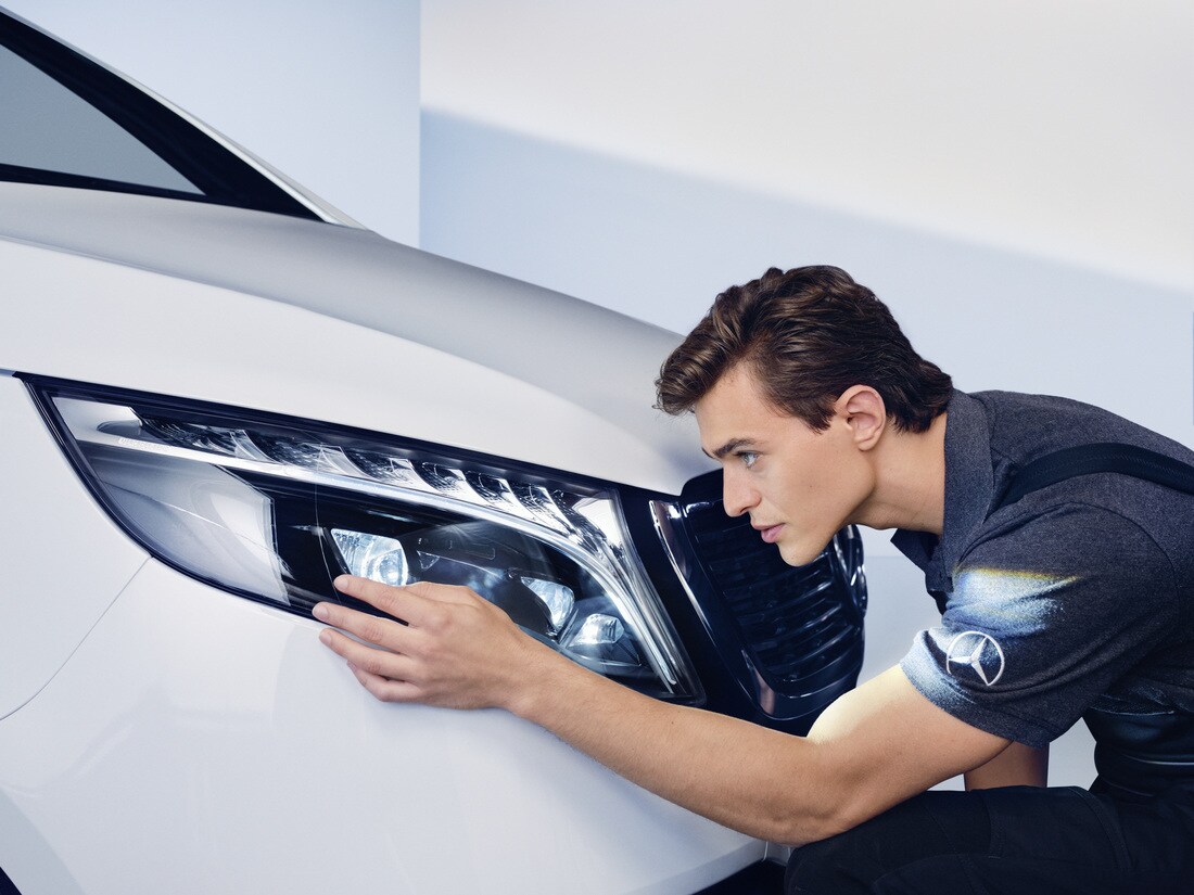 Uma especialista da Mercedes-Benz fazendo a manutenção em um automóvel.