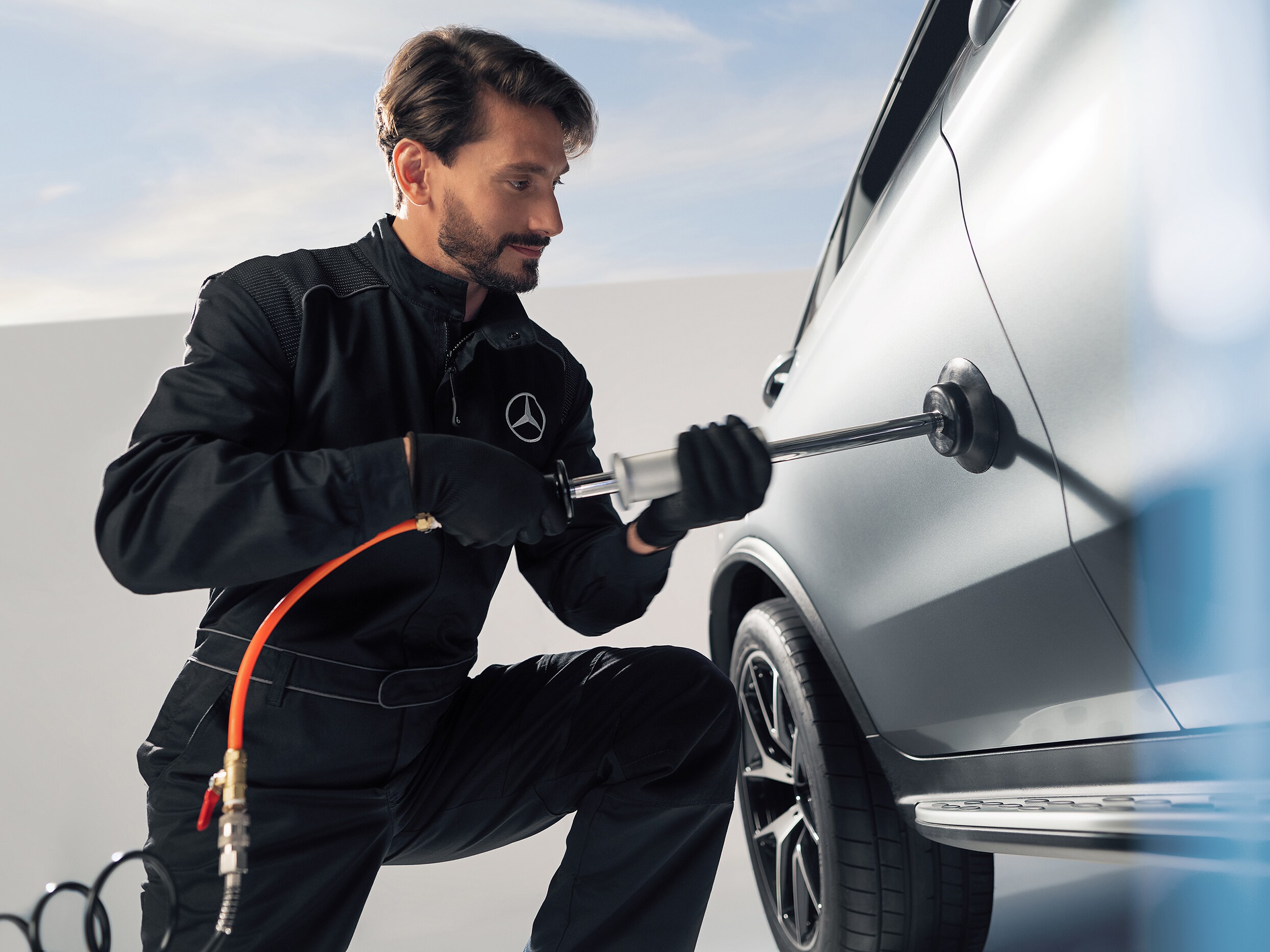 Um técnico da Mercedes-Benz conserta uma avaria na lataria de um veículo.
