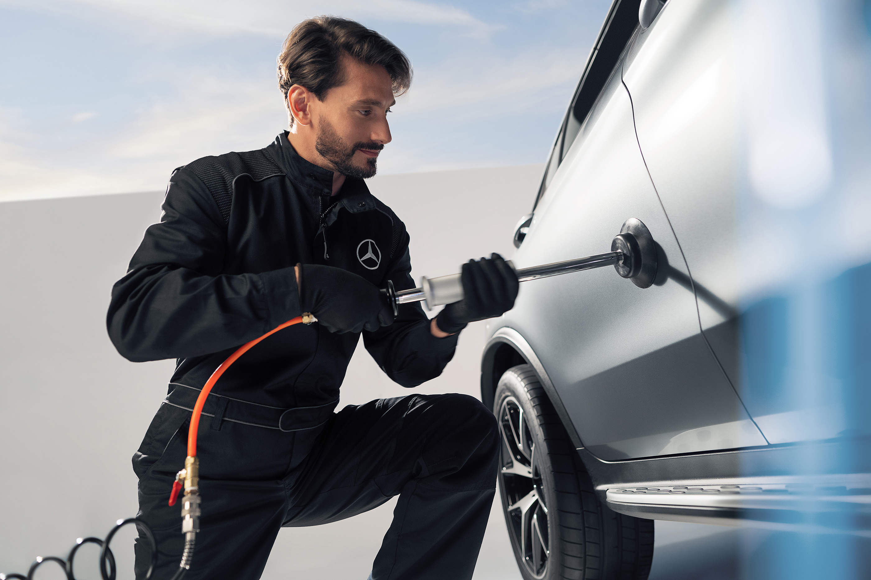 Pequenos reparos Um técnico da Mercedes-Benz conserta uma avaria na lataria de um veículo.