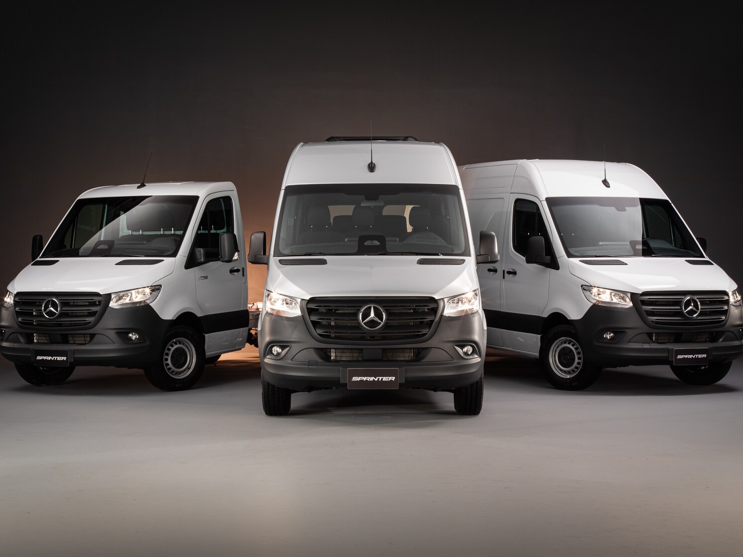 Visão dianteira de três vans Sprinter Mercedes-Benz