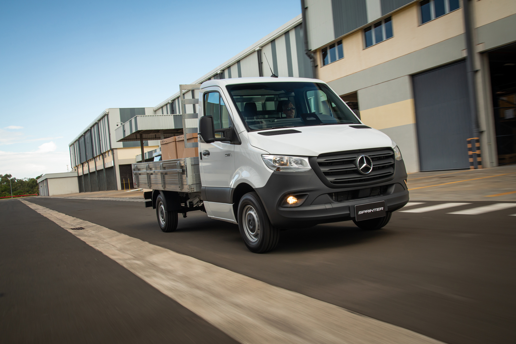 Sprinter Truck | Câmbio Automático | Mercedes-Benz Vans Uma Sprinter Truck com câmbio automático em uma rua.