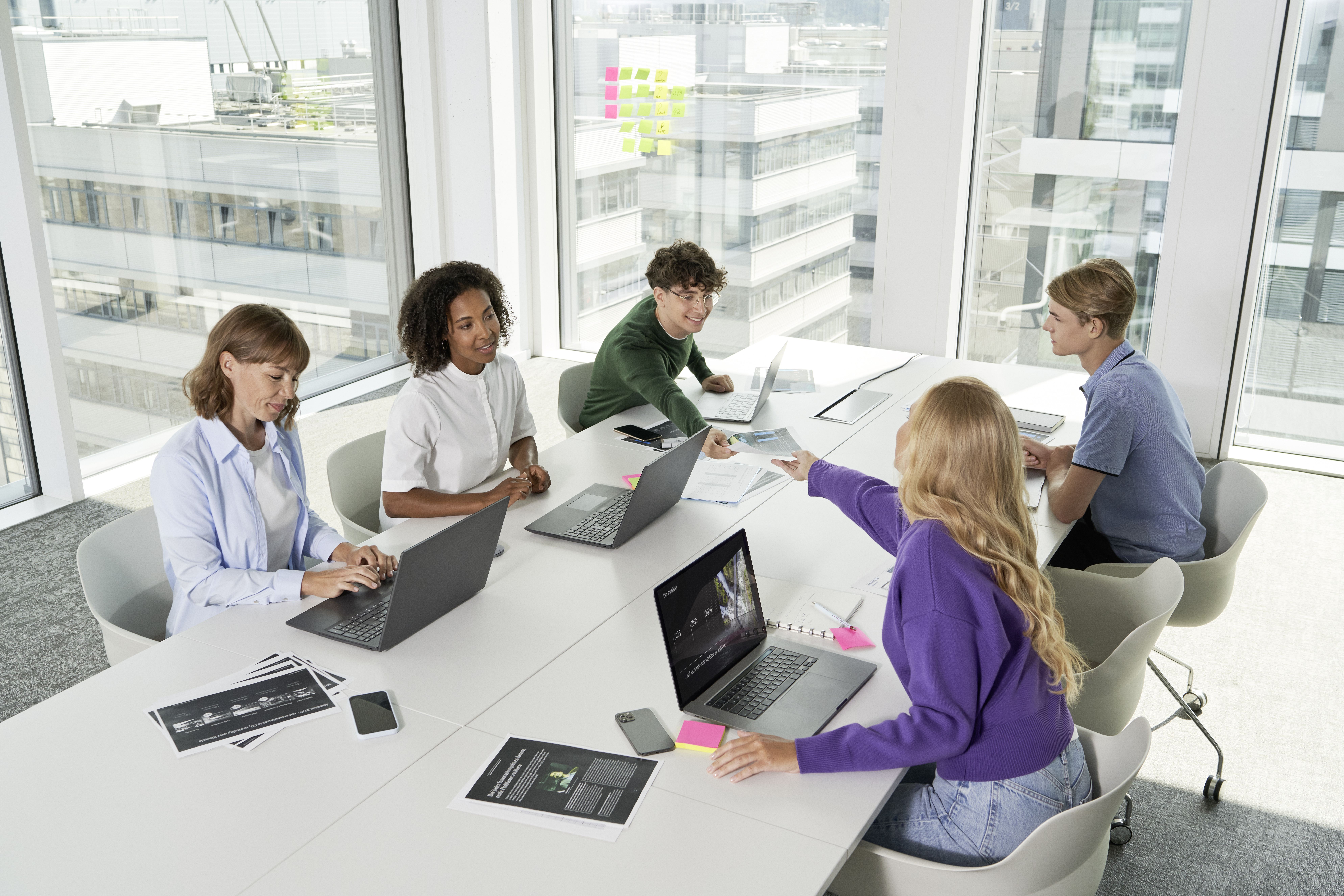 Mercedes-Benz: carreira Várias pessoas conversando e trabalhando juntas em um prédio da Mercedes-Benz.