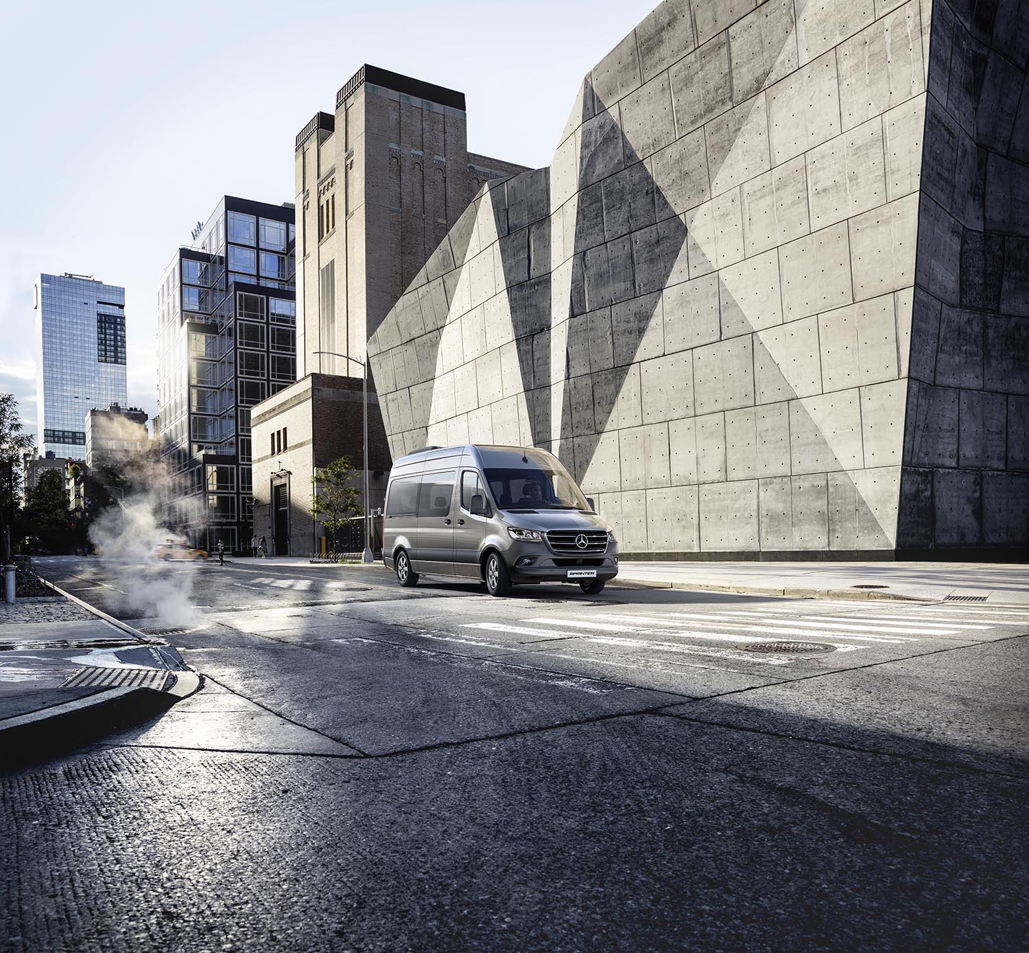 O Sprinter Van Passageiro da Mercedes-Benz em frente a um prédio.