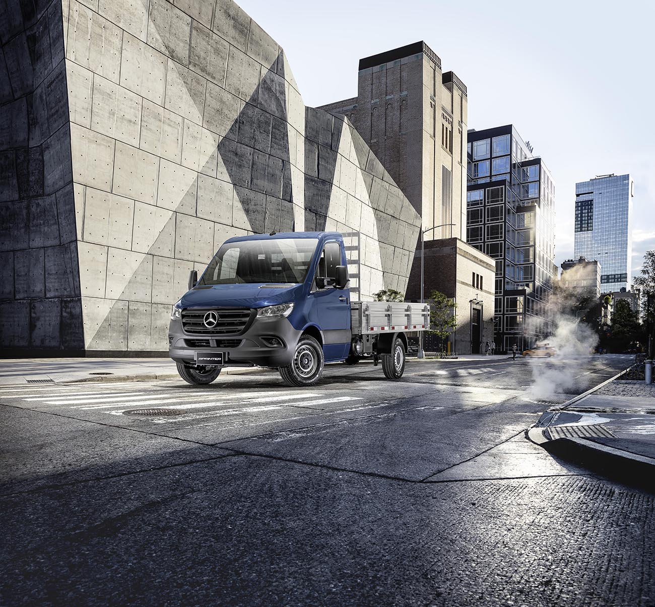 Um Sprinter Truck da Mercedes-Benz ao lado de um prédio.