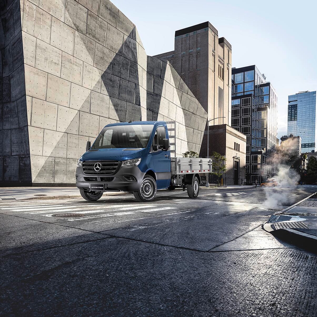Um Sprinter Truck da Mercedes-Benz ao lado de um prédio.
