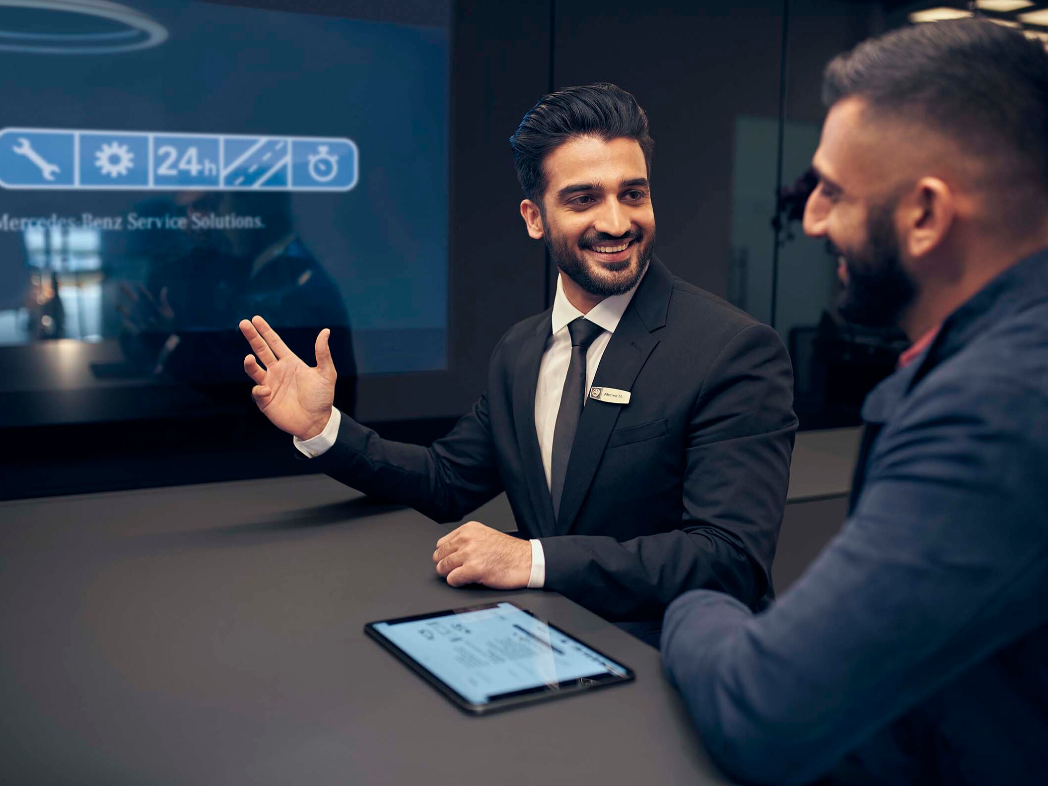 Dois homens conversando no interior de um concessionário Mercedes-Benz.