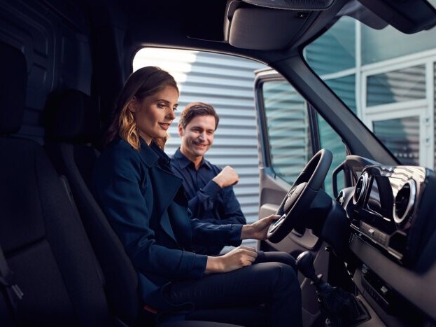 Duas pessoas avaliando o interior de um Mercedes-Benz Sprinter