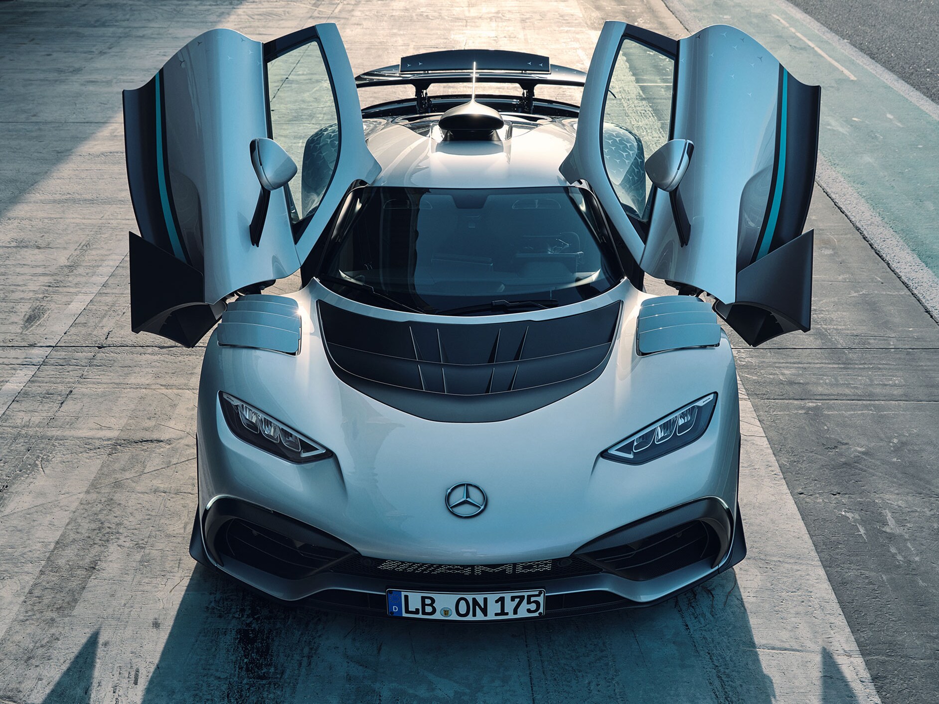 O Mercedes-AMG ONE em uma perspectiva dianteira com as portas abertas.