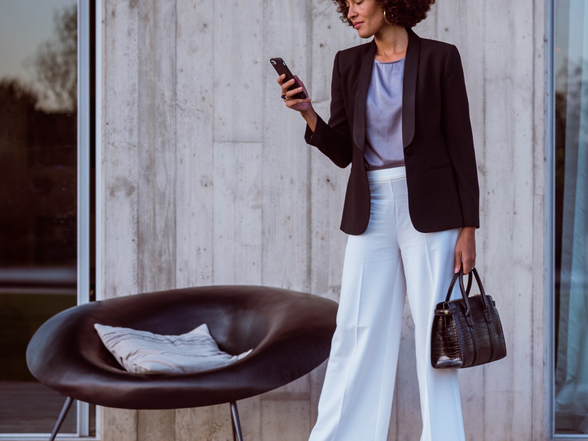 Uma mulher se conecta ao seu Mercedes Benz pelo smartphone, pelo aplicativo Mercedes me e com sua Mercedes me ID.