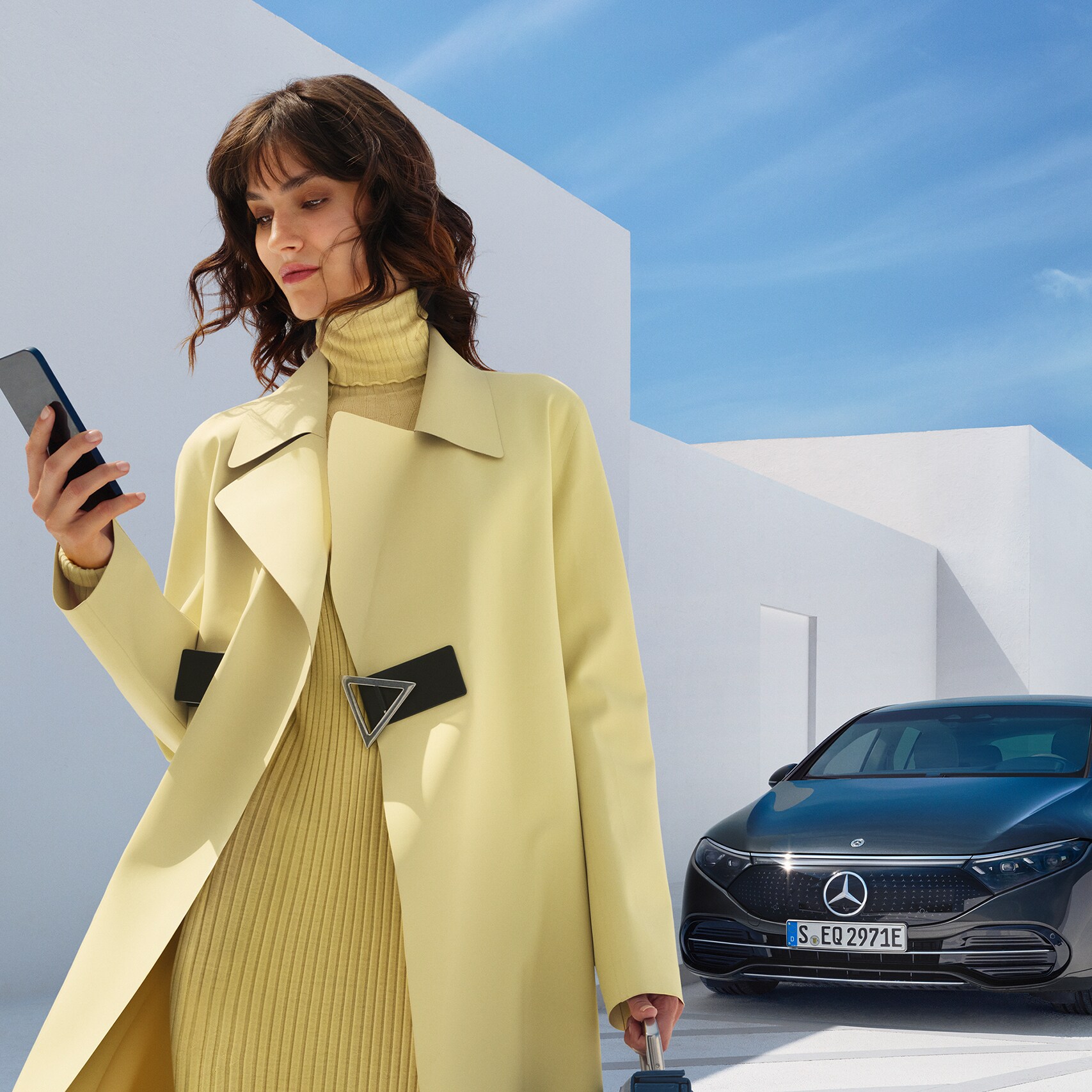 Uma mulher abre o Mercedes me App em seu smartphone.