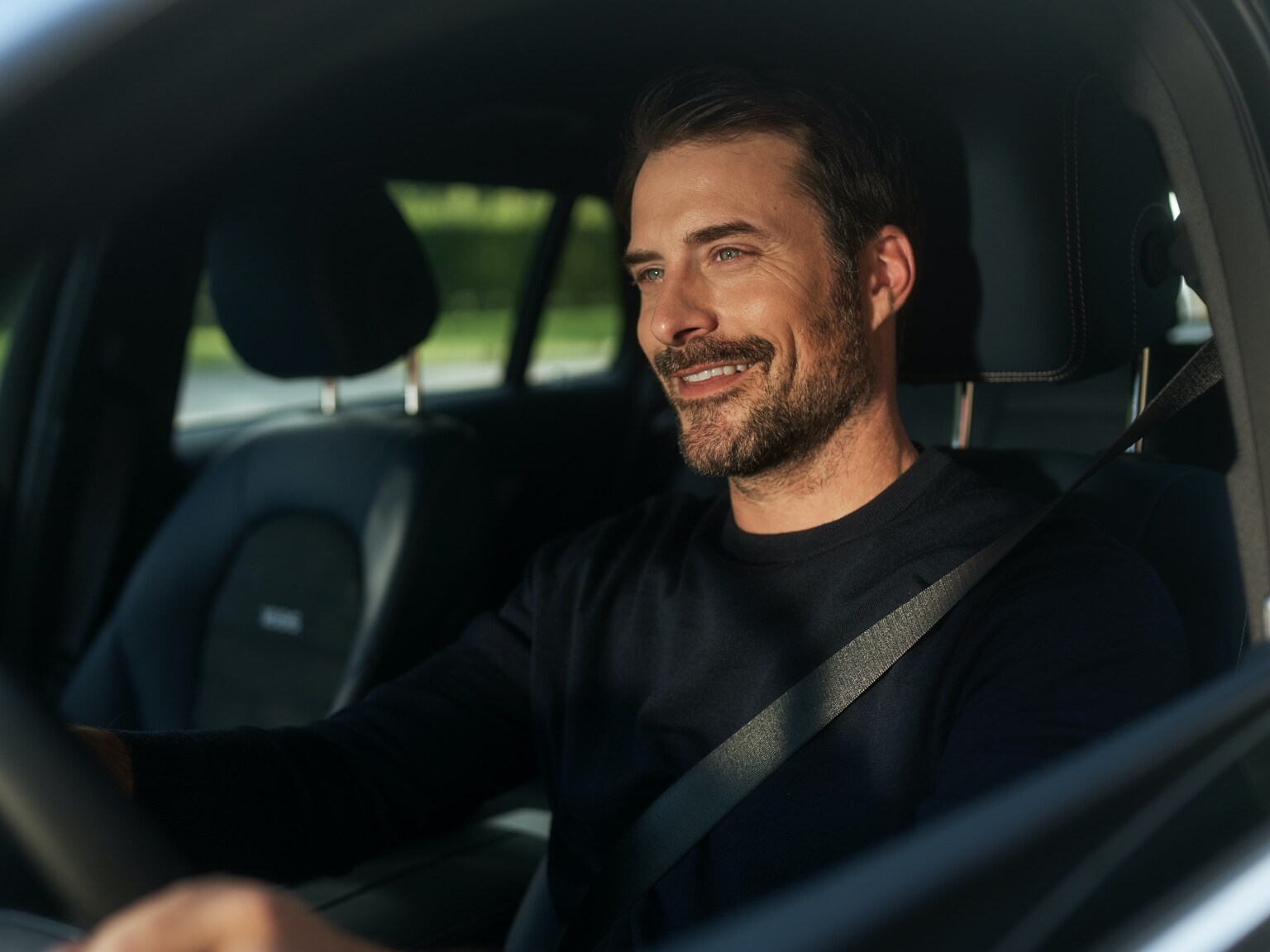 Um homem escuta rádio internet sem interrupção no seu Mercedes-Benz graças ao Pack Entretenimento.