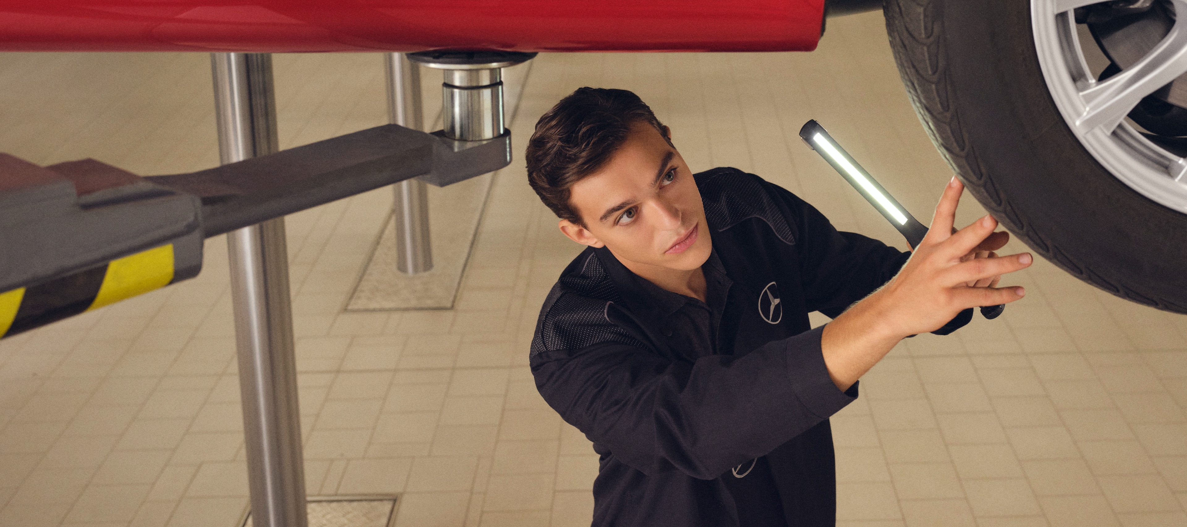 Pneus Mercedes Original | Mercedes-Benz Um mecânico da Mercedes-Benz realiza uma troca do pneu.