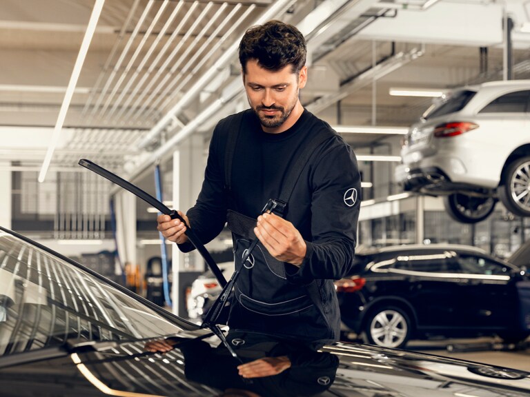 Um técnico da Mercedes-Benz realiza uma substituição do limpador do para-brisas.