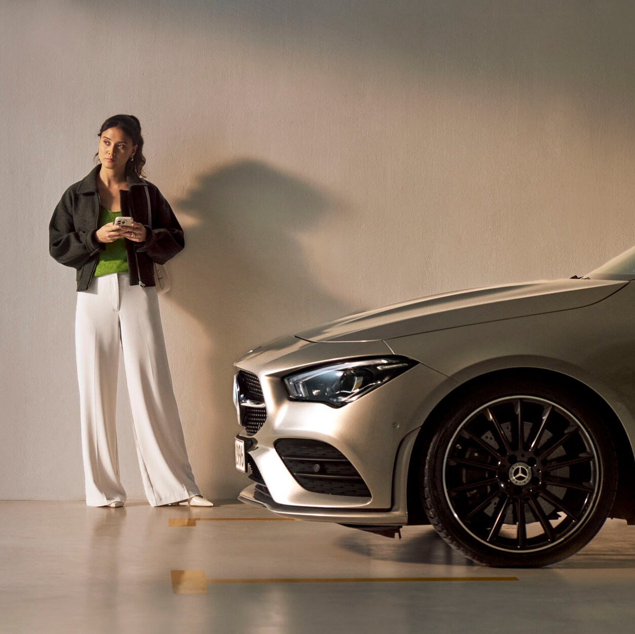 A person stands in front of a Mercedes-Benz vehicle.