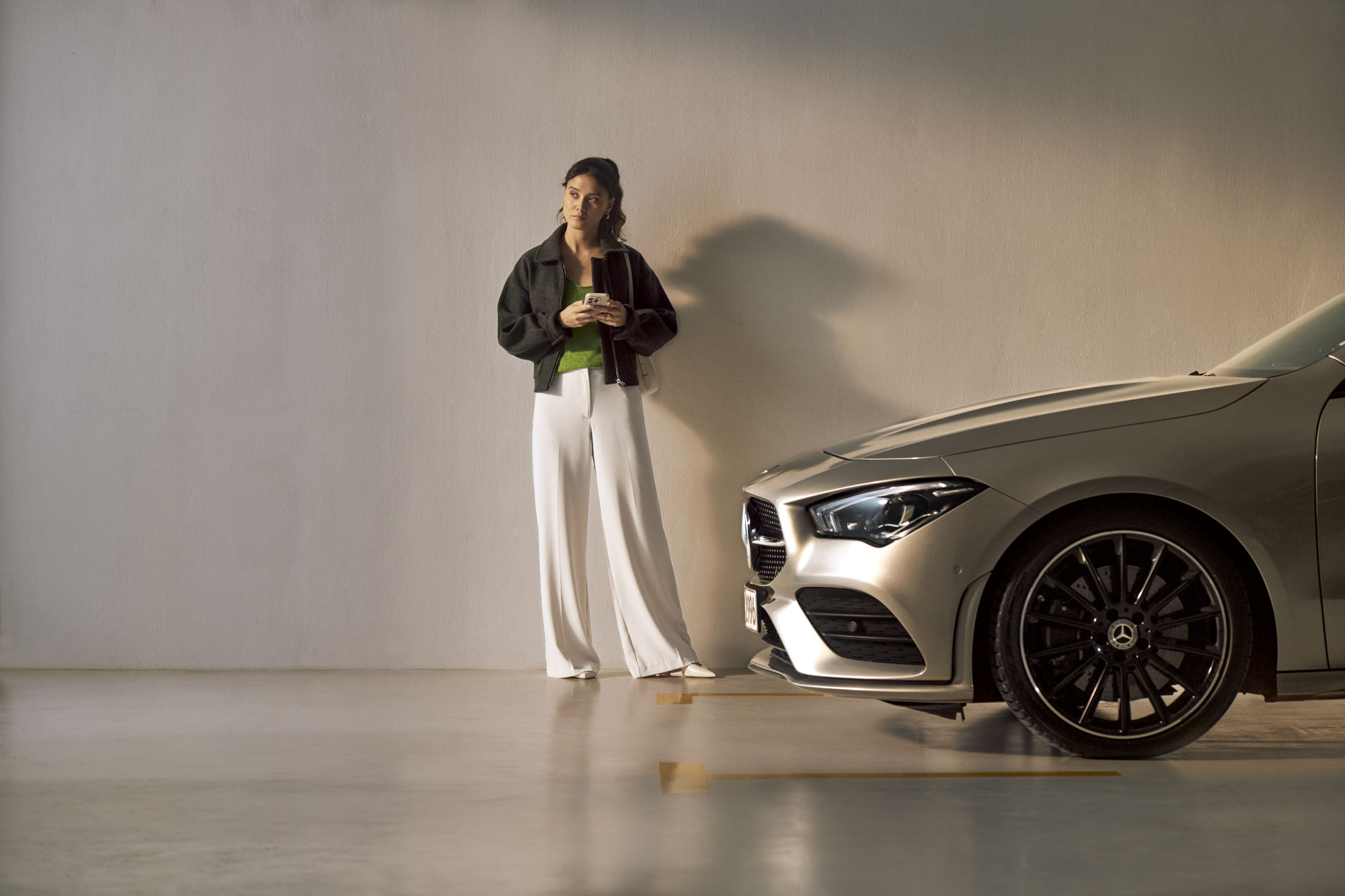 Service Select | Mercedes-Benz A person stands in front of a Mercedes-Benz vehicle.