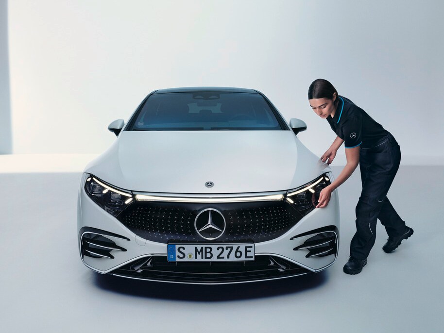 Um técnico da Mercedes-Benz está verificando um veículo.