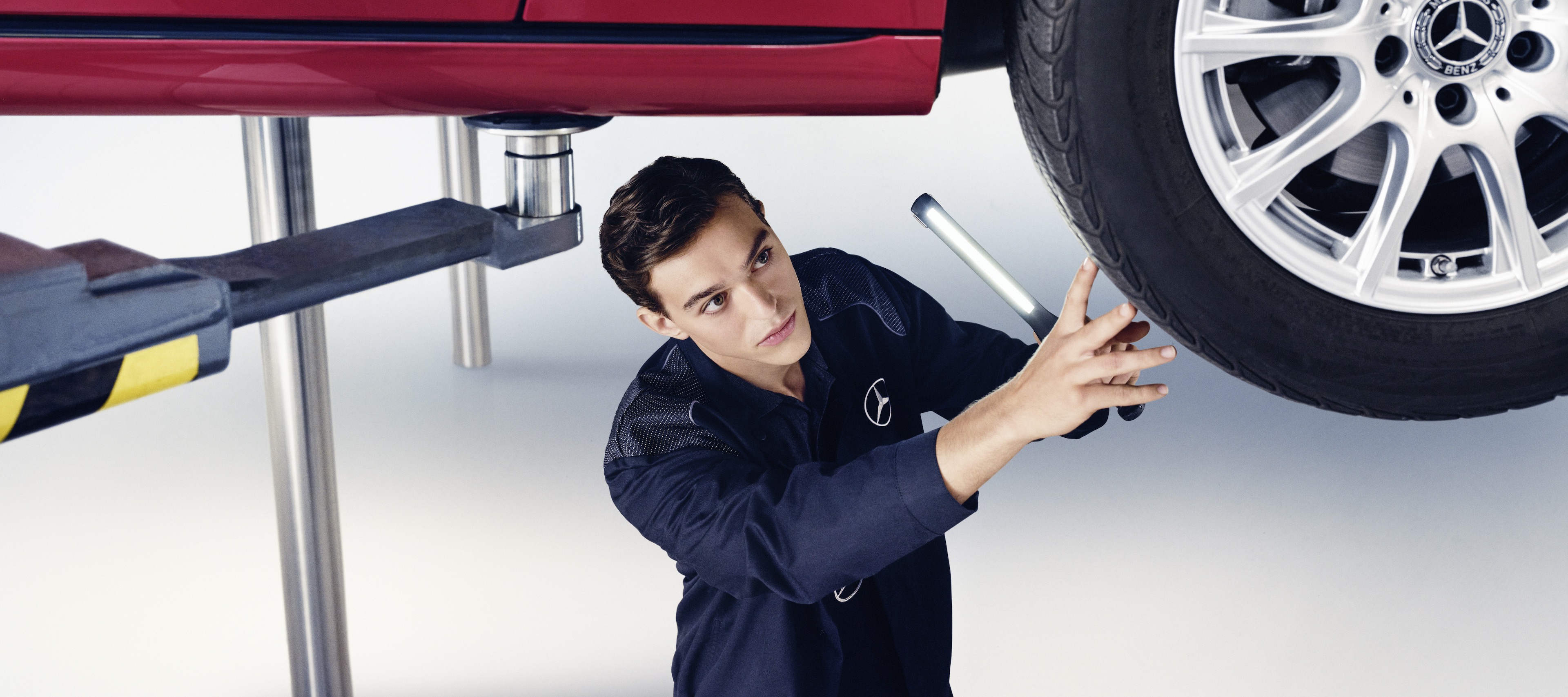 Contratos de manutenção | Mercedes-Benz Um especialista da Mercedes-Benz realizando a manutenção em um automóvel.