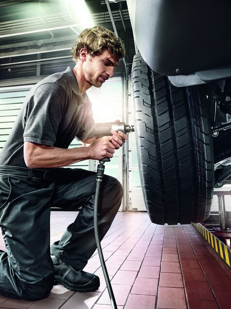 Um mecânico realizando a revisão na roda de uma van Sprinter.